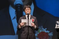 女性部門受賞作「ベル・プペーのスパダリ婚約～『好みじゃない』と言われた人形姫、我慢をやめたら皇子がデレデレになった。実に愛い！～」の関係者として登壇したスクウェア・エニックスの佐々木克之氏