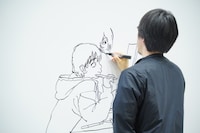 押山監督のライブドローイングの様子。京本も同じく目元から描き始めた