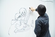 押山監督のライブドローイングの様子。この後描いていく小道具のサイズ感を確認