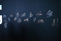 サインウォールに書かれたキャストたちのサイン