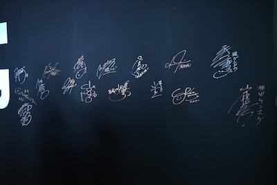 サインウォールに書かれたキャストたちのサイン