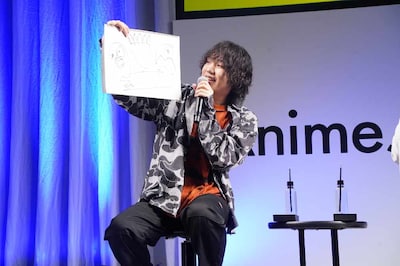 吉永拓斗。フリップには怪獣に襲われる鉄男の姿が描かれている