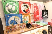4月1日より販売される「ONE PIECE CAFE GENE」の新グッズ、再入荷グッズ。右側にかけられているフェイスタオル、平置きされているメタリッククリアファイル、「ブルックヘッドボウル」、「樽マグ」は新発売。左にかかっている和風バンダナは再販売。