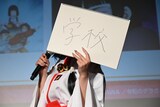 風吹ケイがスケッチブックに「学校」と書く
