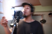 リリックを手にマイクの前に立つ「THE COCKPIT」のワンシーン。(c)Aichi Arts Center, MIYAKE Sho