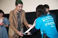 しゃもじを新宿ピカデリーのスタッフに渡す松田龍平。(c)2015 いがらしみきお・小学館／『ジヌよさらば～かむろば村へ～』製作委員会　配給：キノフィルムズ