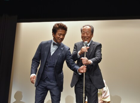 左から風間トオル、岸部一徳。岸部の手助けをする風間と、パフォーマンスが好評を得てうれしそうに笑う岸部。