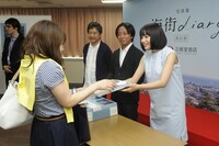 来場者に写真集を手渡す広瀬すず。