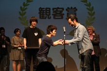 古舘寛治からトロフィーを受け取る中村祐太郎。