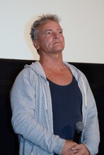 「ご覧の通り我々は生きている」と報告する、ジョニー・ザ・ボーイ役のティム・バーンズ。