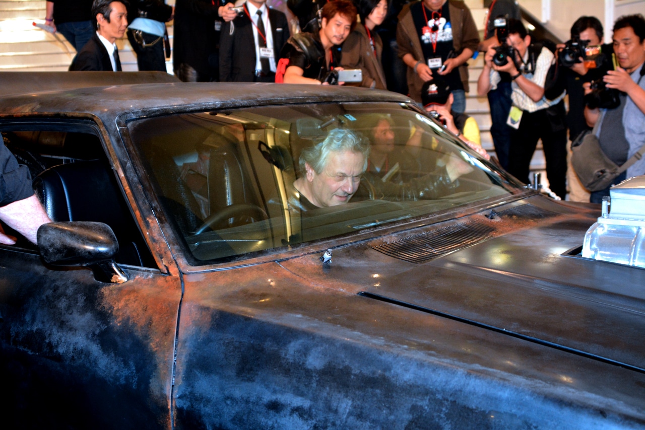 インターセプターのレプリカに乗車するジョージ・ミラー。