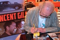 ファンが持参した撮影用小道具にサインするヴィンセント・ギル。