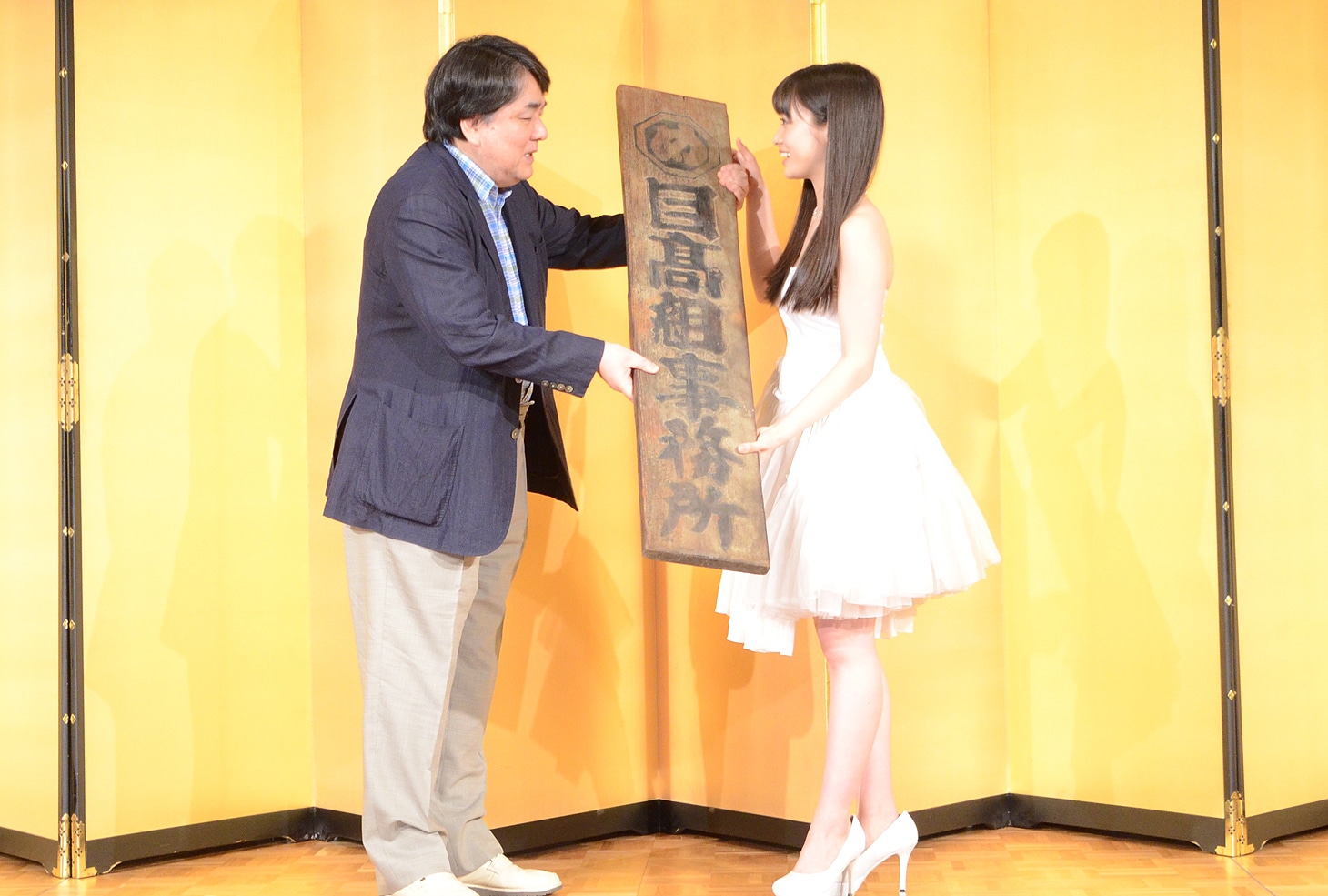 赤川次郎が橋本環奈へ、1981年の「セーラー服と機関銃」の撮影で使われた“目高組”の看板を渡す様子。
