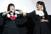 「脳漿炸裂ガール」冒頭映像上映会にて、震える演技を披露する柏木ひなた（左）、それをサポートする竹富聖花（右）。(c)2015 映画「脳漿炸裂ガール」製作委員会