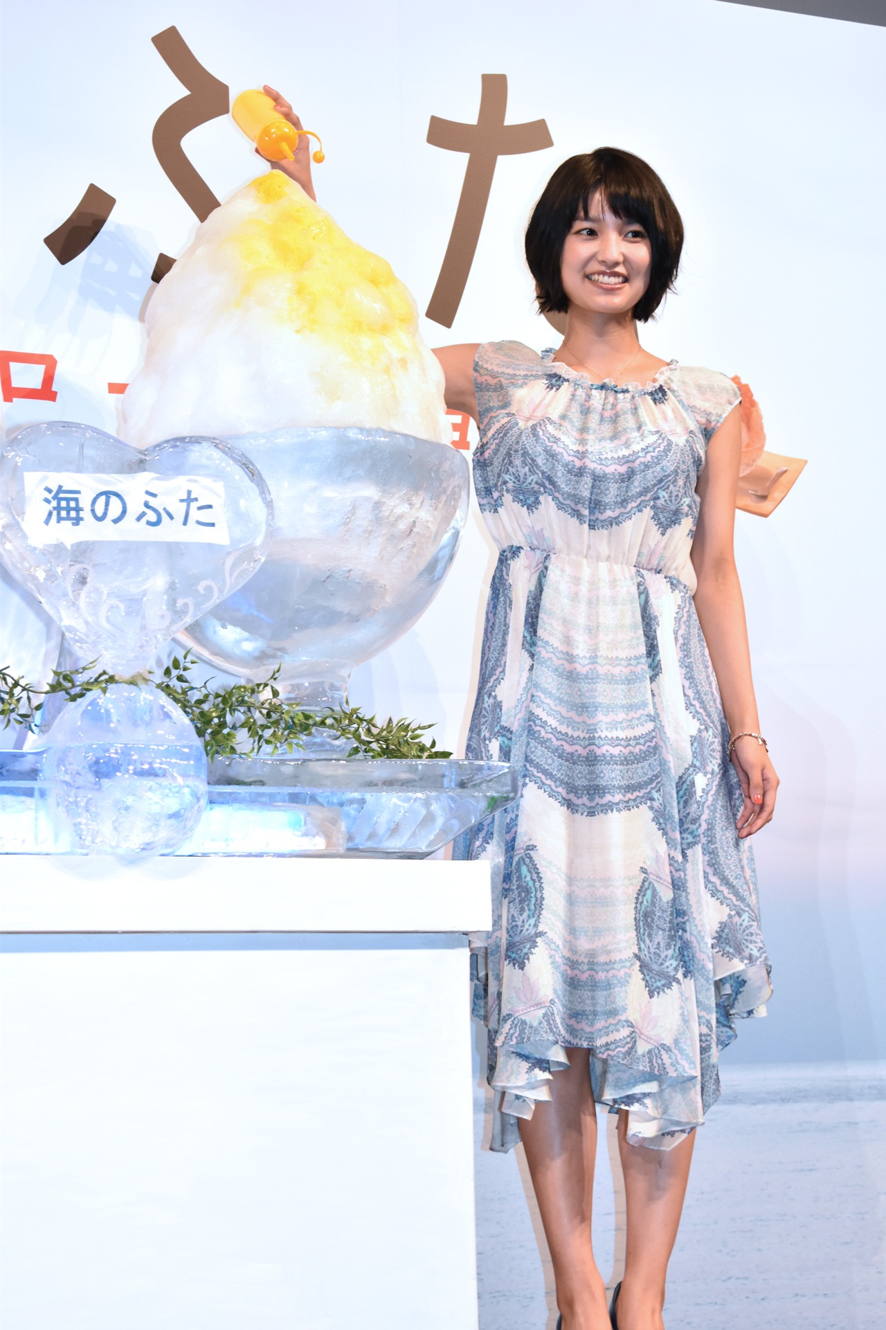 演出の巨大かき氷にシロップをかける三根梓。