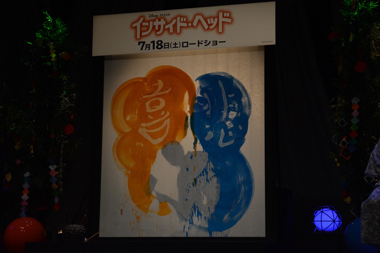 紫舟によるライブパフォーマンスの様子。裏から青の色を乗せ、「悲」の文字を浮かび上がらせる。