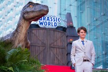 会場に設置された恐竜の前に立つタイ・シンプキンス。