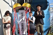 ロマンスカーの前でくす玉を割る大島優子、大倉孝二、タナダユキ。