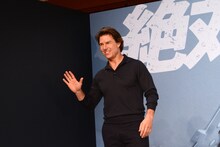 さわやかな笑顔で手を振るトム・クルーズ。