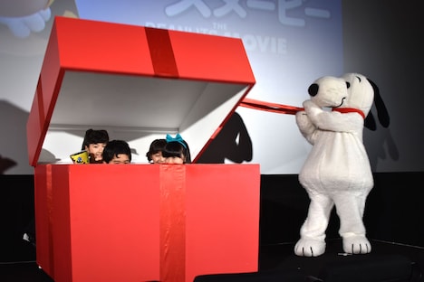 誕生日プレゼントを開けるスヌーピーと、箱の中に潜んでいた子役たち。