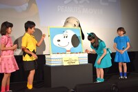 スヌーピーにケーキを食べさせてあげる子役たち。