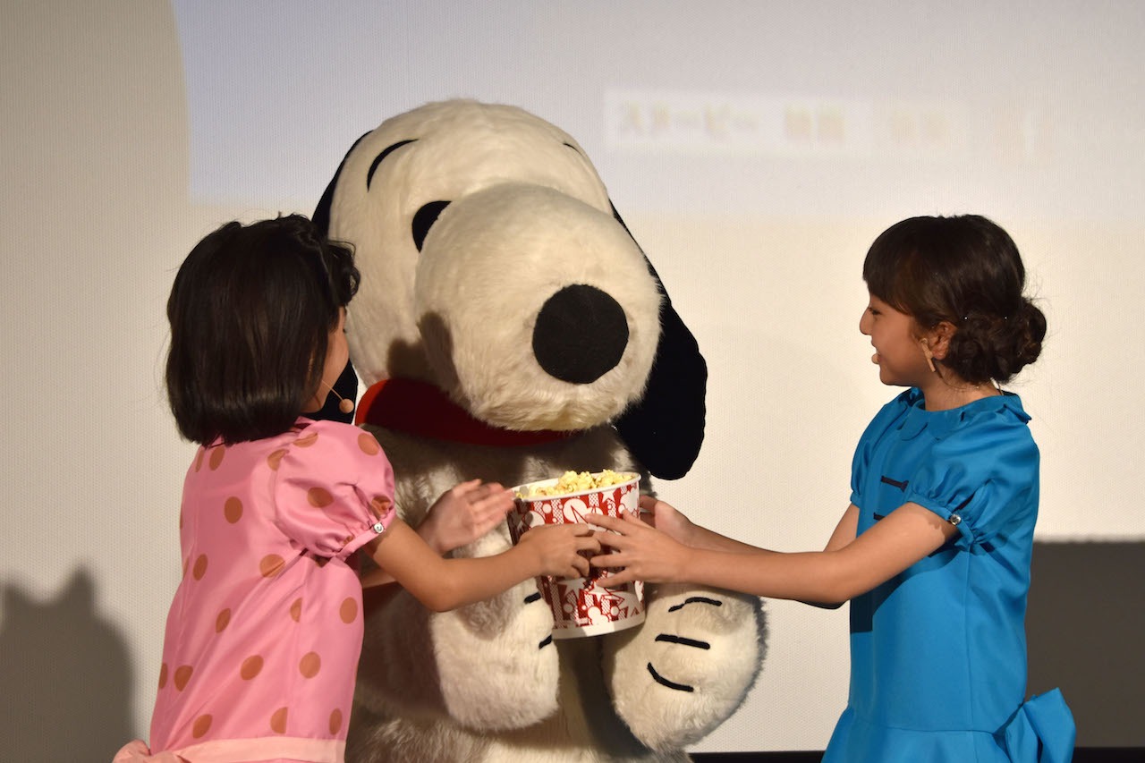 スヌーピーにポップコーンをプレゼントする小林星蘭（左）と谷花音（右）。