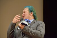 若い俳優と並ぶにあたりマスクを付けて登壇したが、息がつらくなり外した稲田徹。