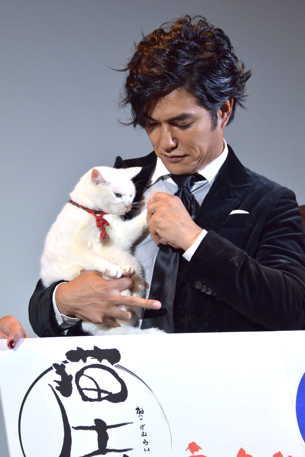 衣装についたあなごの毛を取る北村一輝。