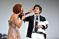 左からLiLiCo、北村一輝。北村の顔についたあなごの毛を取ってあげようとするLiLiCo。