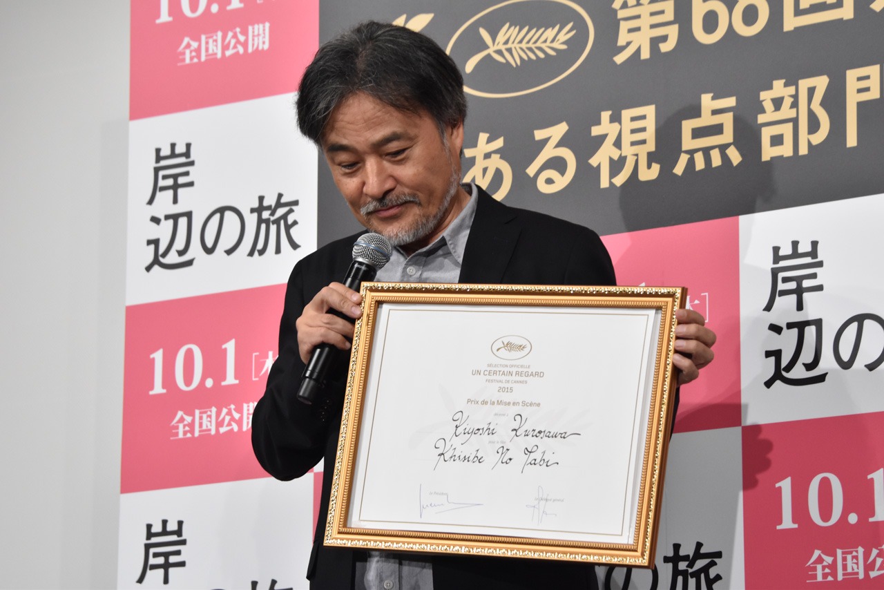 第68回カンヌ国際映画祭ある視点部門の監督賞を獲得した際に受け取った賞状を見せる黒沢清。