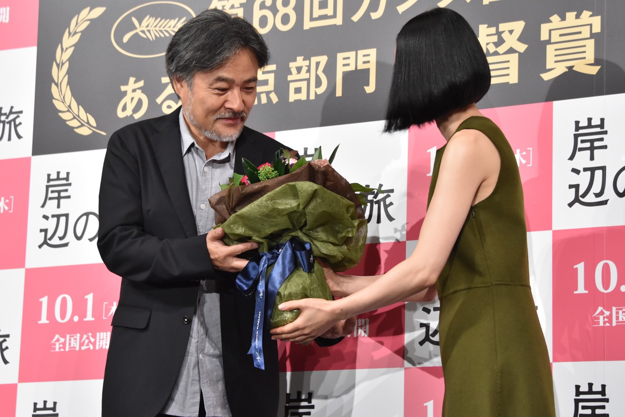 左から黒沢清、深津絵里。受賞を祝い、花束を贈呈する場面。