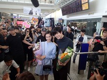 香港国際空港で歓迎を受ける三浦春馬（右）、水原希子（左）。