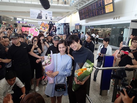 香港国際空港で歓迎を受ける三浦春馬（右）、水原希子（左）。