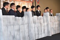 壁の後ろに立つ登壇者たち。