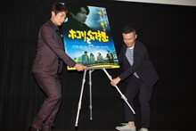 フォトセッションのため、鈴木聖史（右）とともに自らポスターの位置を調整する戸次重幸（左）。