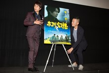 鈴木聖史（右）とともにポスターの位置を調整し、「ここでいいですか？」と確認する戸次重幸（左）。