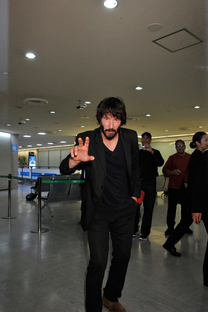 成田空港にて、カメラに向けてポーズを取るキアヌ・リーヴス。
