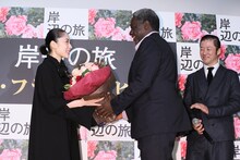 花束を受け取る深津絵里（左）とそれを笑顔で見守る浅野忠信（右）。