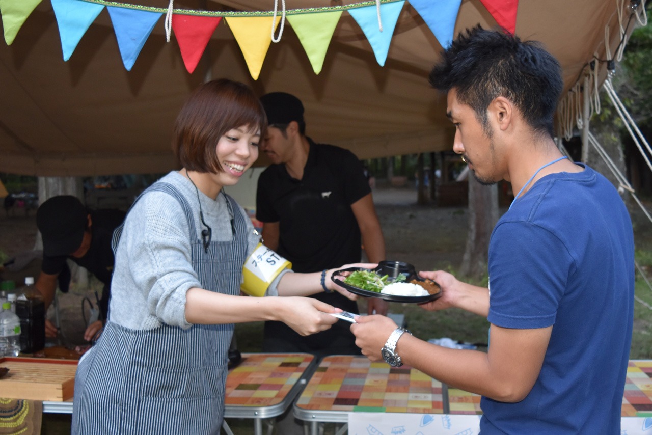 焼肉・芝浦の牛スジカレーが参加者たちに手渡される様子。