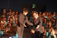 通路を通る順番を譲り合う松坂桃李（左）と石坂浩二（右）。