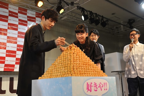 “たこ焼きタワー”のたこ焼きを食すキャストたち。