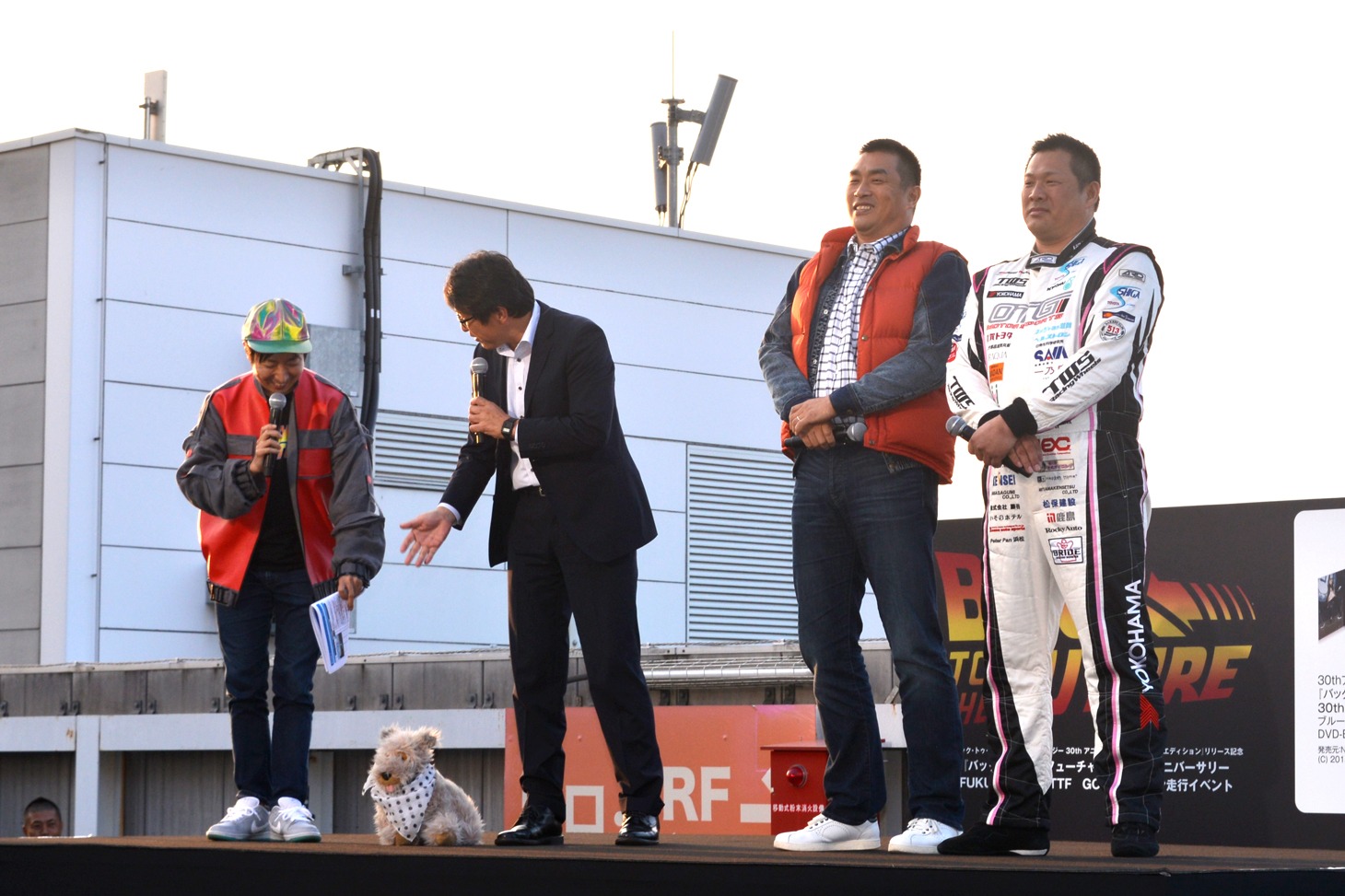 ドクの愛犬・アインシュタイン風のぬいぐるみを連れてきた、日本環境設計代表の岩元美智彦氏（左から2番目）。