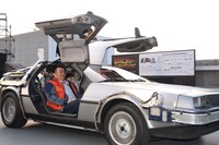 走行するデロリアンと、笑顔の山本昌。