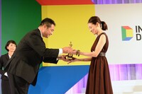 トロフィーを受け取る吉田羊（右）。