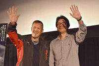 テレビカメラに手を振る辰吉丈一郎（左）と阪本順治（右）。