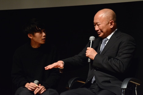 子犬の大きさを手で示すジョン・ウー(右)。