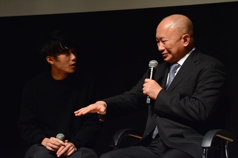 子犬の大きさを手で示すジョン・ウー（右）。