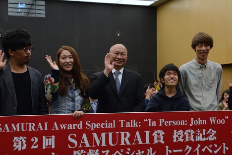 日本の若手監督とともにカメラに向かって手を振るジョン・ウー（中央）。