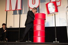 ダルマ落としの頭の部分を木槌で飛ばすビートたけし。