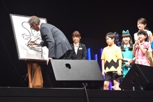 スティーヴ・マーティノ（左）がスヌーピーを描くのをじっと見つめる子役たち。